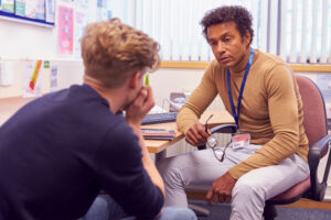 Male counselor working with young male student