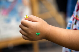 Little girls hand covered in star stickers