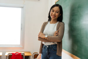 Young teacher standing in front of chalkboard