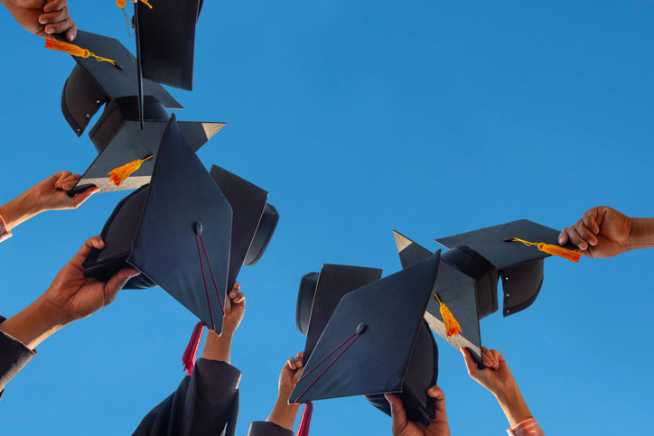 graduates with caps in the air