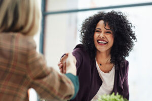 Graduate smiling and shaking hands at a job interview, career opportunities with a master's in ABA