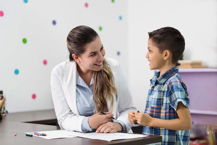 young boy smiling at therapist