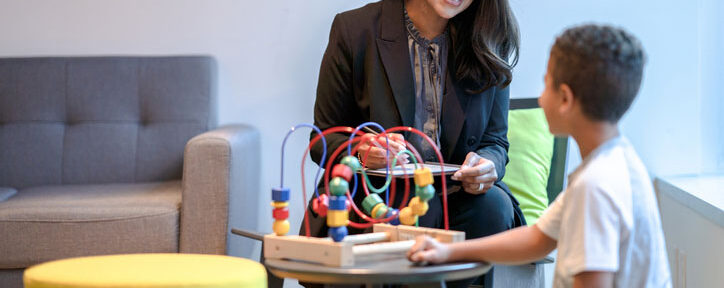 aba therapist playing with young boy in therapy