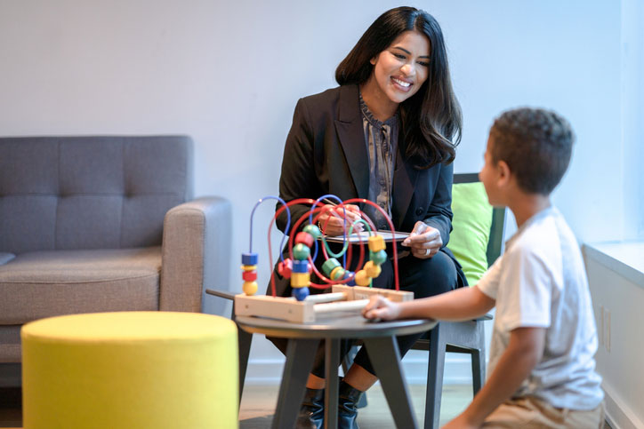 aba therapist playing with young boy in therapy
