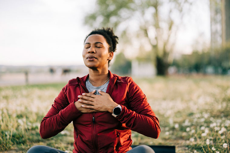 woman meditating in field
