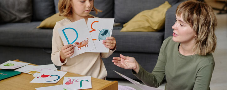 mom and daughter studying alphabet letters at home